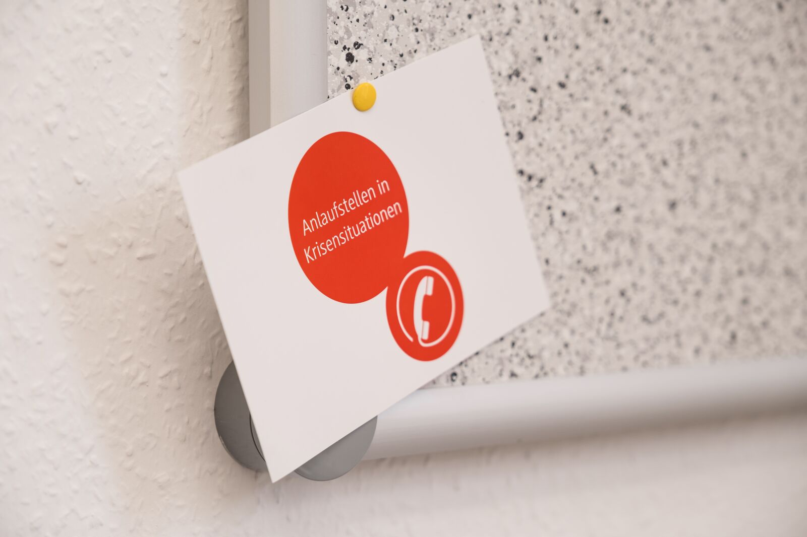 Das Foto zeigt einen Flyer mit dem Aufdruck "Anlaufstellen in Krisensituationen"