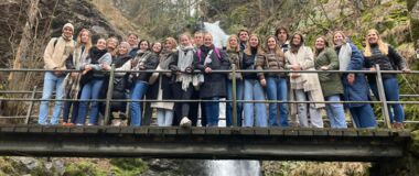 Eine Studierendengruppe steht auf einer Brücke, im Hintergrund sind die Triberger Wasserfälle zu sehen.